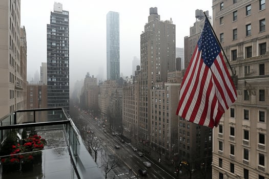 A view of a city from a balcony with a flag photo