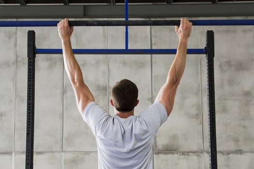 A man is doing pull ups on a pull up bar photo