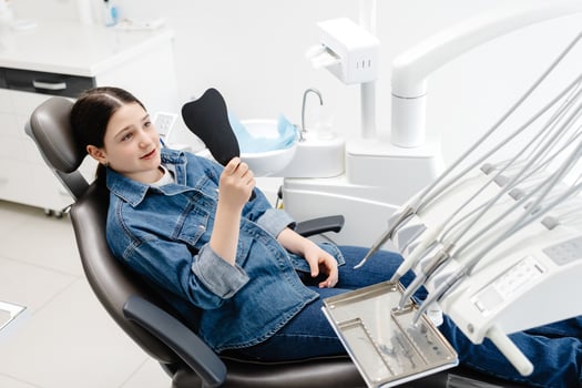 Young patient admiring smile after dental checkup. photo