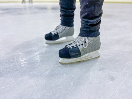 Hockey player standing on ice rink wearing ice skates photo