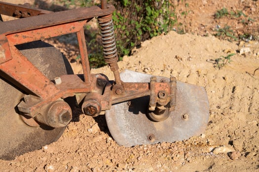 Plowing action agricultural field machinery close-up rural environment ground level farming concept photo