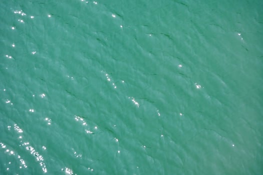 Water surface topview. Sun glare on water. Background abstracted wallpaper texture. photo