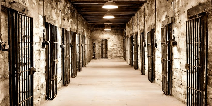 Old Prison Corridor Jail Cells Stone Walls Metal Bars photo