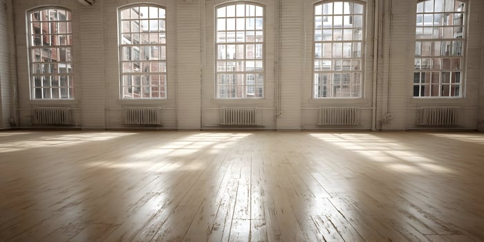 an empty room with lots of windows and wood floors photo