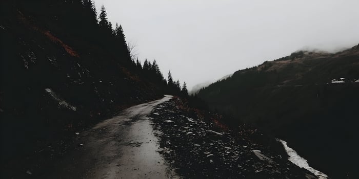 Misty Mountain Road Winding Through Dark Forest Landscape photo