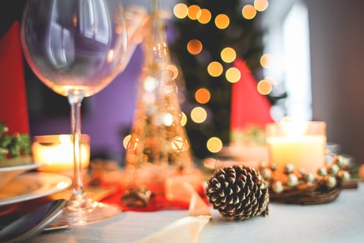Festive table setting with wine glass candle and pine cone for a holiday celebration mood light photo