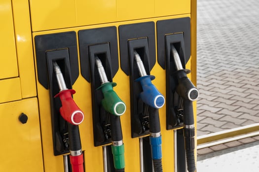 Bright yellow gas station pump with four fuel nozzles in red, green, blue, and black colors for different octane grades photo