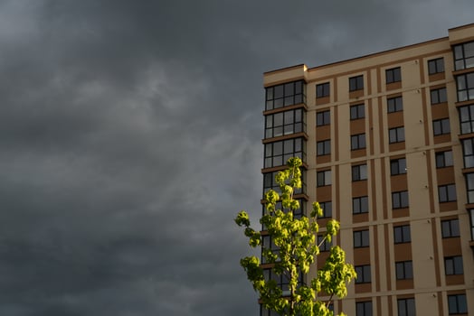 Apartment Building Exterior Under Overcast Sky With Green Tree Foliage photo