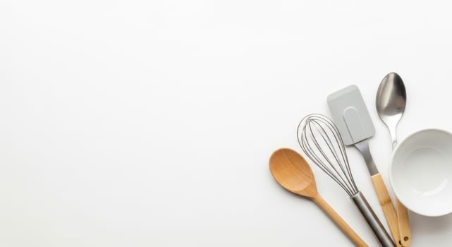 Kitchen Utensils Still Life Wooden Spoon, Whisk, Spatula, and Bowl on White Background photo