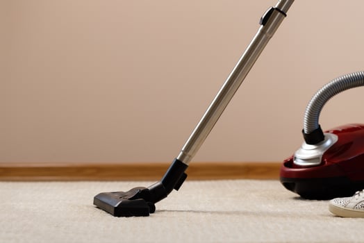 Red vacuum cleaner on a beige carpet photo