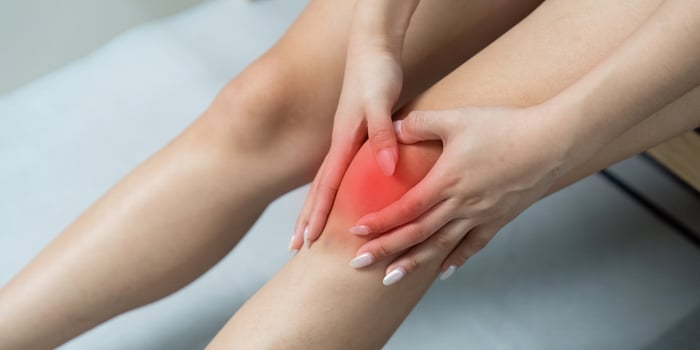 Knee Pain Management. Woman holding her knee in discomfort. photo