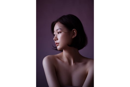 Portrait of asian woman with short dark hair and bare shoulders looking to the side photo
