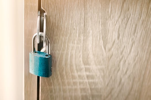 Close-up of key to lock or unlock a padlock on a wooden door, symbolizing security, privacy, and access control and confidential data, safe solutions for home or represents protection concept. photo