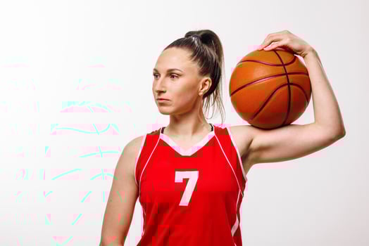 Confident Female Basketball Player in Red Jersey Holding Ball on Shoulder Isolated on White photo