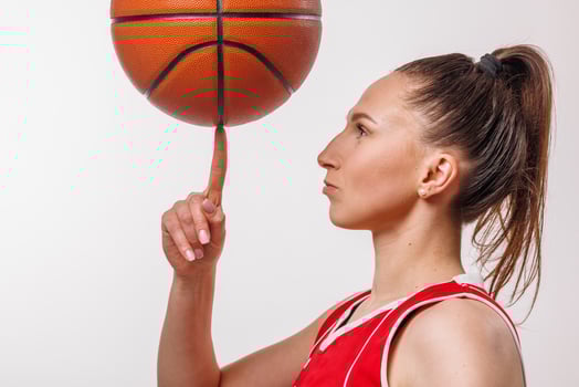 Female Basketball Player Balancing Ball on Finger, Isolated Portrait of Skill and Focus in Red Jersey photo