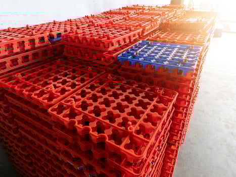 Stack of plastic egg trays in a chicken hatchery industry photo