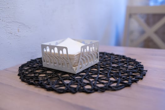 A napkin holder on a table with a black and white napkin photo