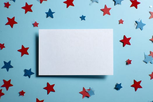 Blank Card Surrounded by Red and Blue Stars on a Light Blue Background for Creative Celebration photo