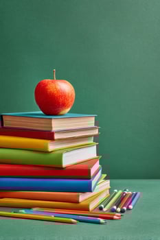Colorful Stack of Books With Red Apple on Top Against Green Background in a Study Environment. photo