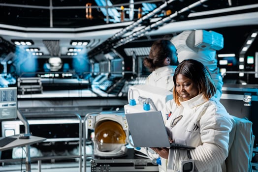 Female astronaut in spacecraft verifying navigation coordinates using laptop device. Woman in spaceship updating flight log on notebook during planetary exploration flight photo