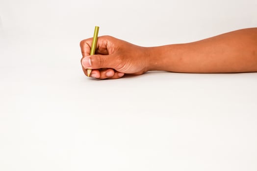 Hand holding a pencil ready to write or draw on a clear white surface photo