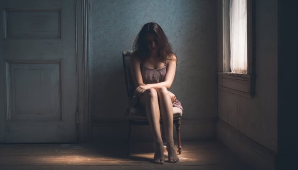 Sad woman sitting alone in a empty dark room and sunlight photo