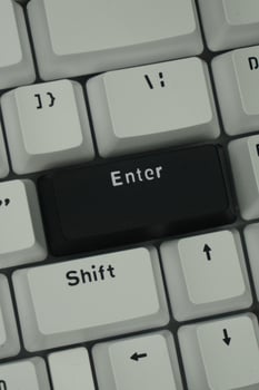 The black enter key on a mechanical keyboard with a monochrome theme in close up mode photo