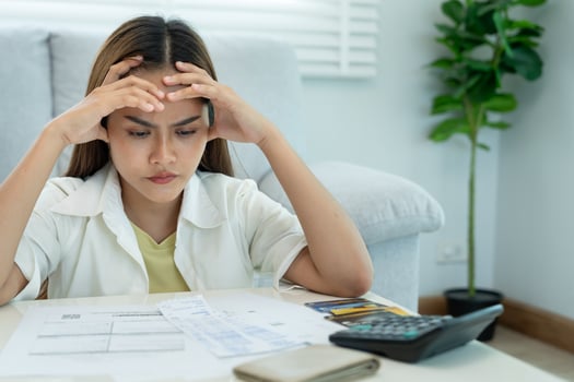 Stressed and headache asian woman with large bills or invoices no money to pay to expenses and credit card debt. shortage, Financial problems, mortgage, loan, bankruptcy, bankrupt, poor, photo