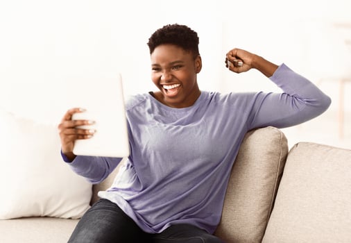 Success. Chubby black female student or employee excited by reading good news in paper letter about new job, great deal, positive exam result, celebrating opportunity offered in written notification photo