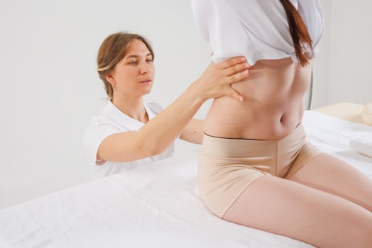 Specialist Examining Patients Lower Spine for Scoliosis, Curvature, Hernia or Postural Deformities photo