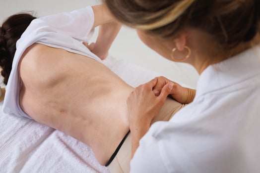 Rehabilitation Specialist Examining Spinal Curvature for Scoliosis or Hernia in Female Patient photo