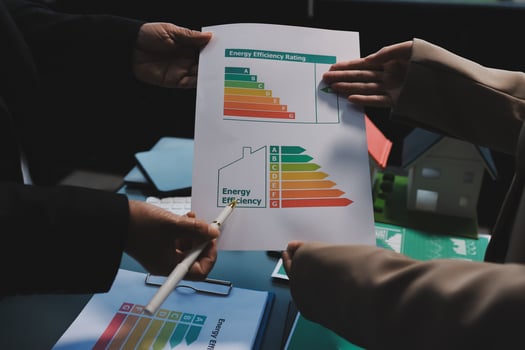 Two people holding a paper with an energy efficiency chart photo