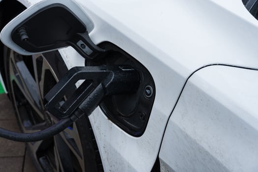 An electric car is being charged at a public station, showcasing the innovative design of the vehicle's power connection photo