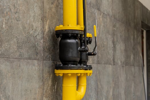 A brightly colored yellow and black gas pipeline connection illustrates the sophisticated technology used for transporting energy in industrial settings photo