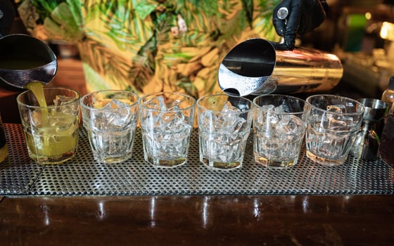 Bartender pouring Cocktail fruits in glass with ice on counter photo