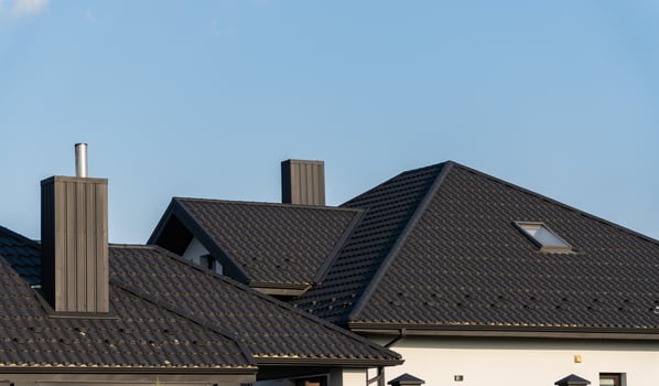 Multiple contemporary rooftops showcase varying architectural styles and materials against a bright sky, emphasizing suburban life and design diversity photo