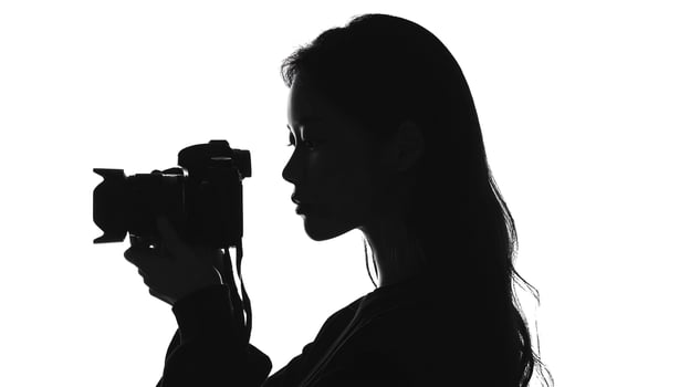 A woman is silhouetted holding a camera photo