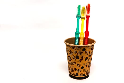 Toothbrushes in a decorative cup on a white background, promoting dental hygiene and wellness photo