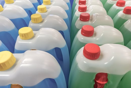 Plastic containers with blue and green windshield washer fluid photo