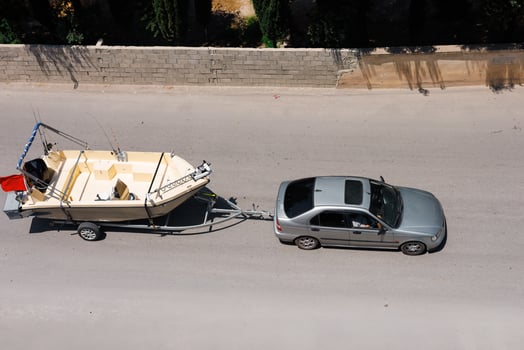 A passenger car is towing motorboat photo