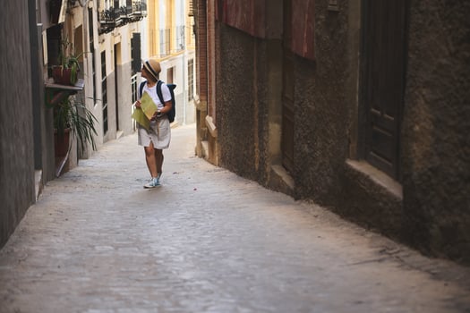 Female Tourist Exploring Medieval Streets with a Map in a Quaint Historic Town photo
