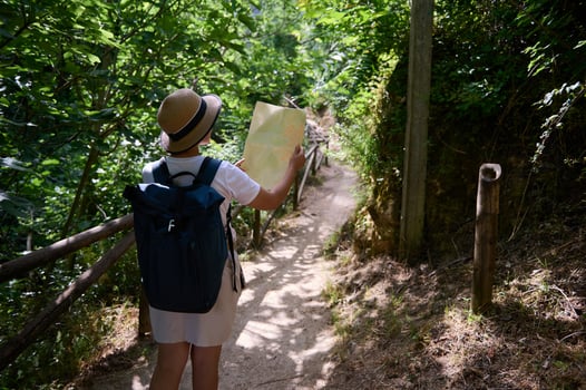 Woman Exploring a Forest Trail While Navigating With a Map photo