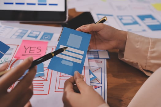 A person is holding a piece of paper with a pen and a tablet photo