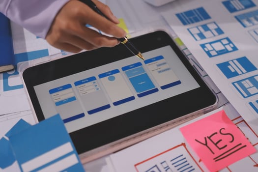 A person using a tablet to design a mobile app photo