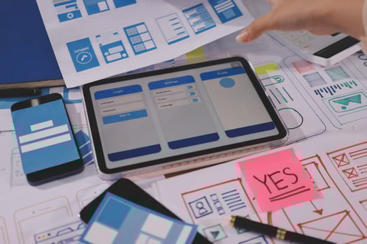 A person is using a tablet to design a mobile app photo