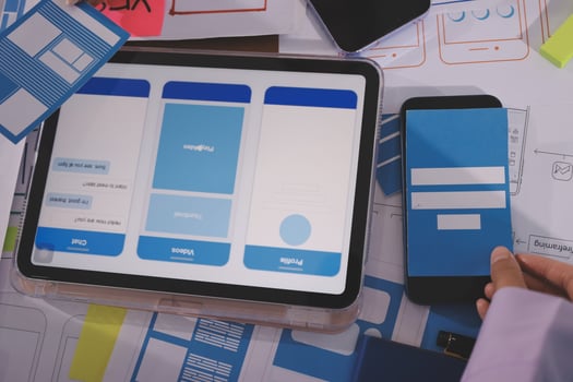 A person using a tablet and a smartphone to design a mobile app photo