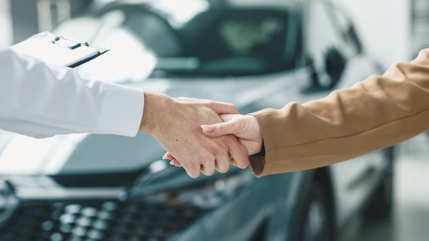 A car dealer completes a deal or a successful consultation by shaking hands with a customer. Concept of a successful purchase and sale. photo
