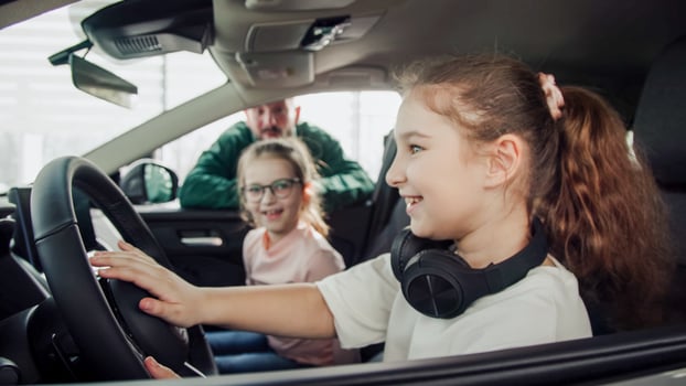A father and his daughters are looking at buying a new car at a modern car dealership. The concept of selling or leasing a new car and vacation. photo