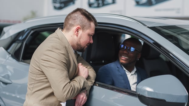 Happy African-American businessman sitting in his new car after buying it. Concept of expensive purchase, lease and test drive or insurance of your car. photo