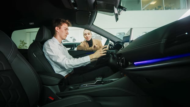 Car dealer showing a car to a customer in a showroom. Concept of purchase and assistance. photo